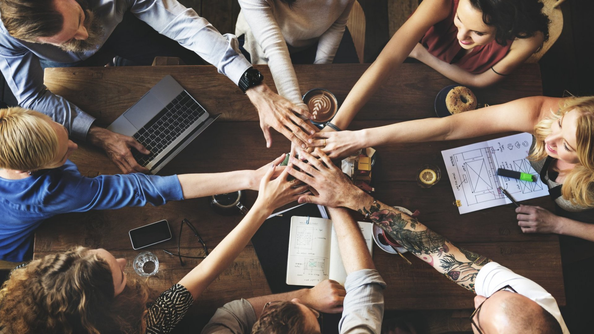 A Group of diverse people holding hands in a meeting